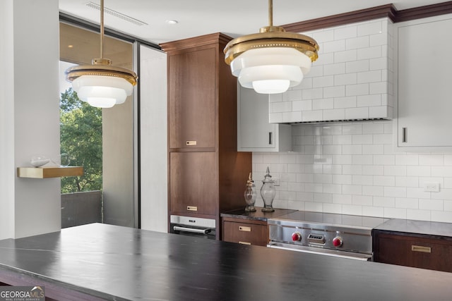 kitchen featuring hanging light fixtures, appliances with stainless steel finishes, and decorative backsplash