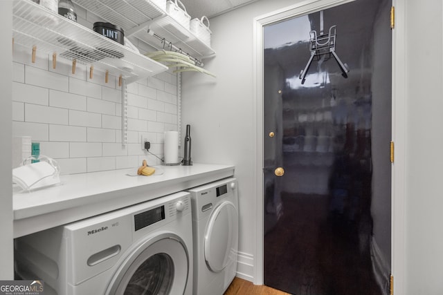 laundry area with wood-type flooring and washer and dryer