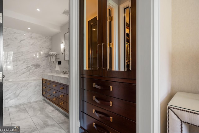 bathroom featuring vanity and tile walls