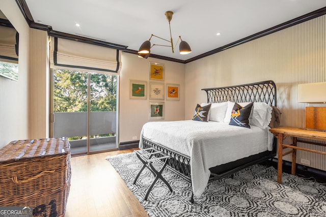 bedroom with ornamental molding, hardwood / wood-style floors, and access to outside