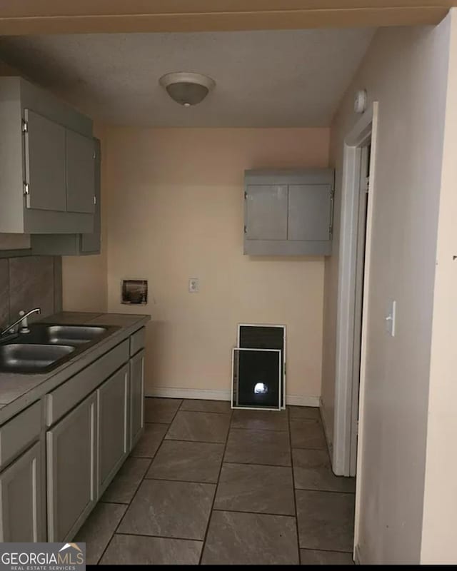 kitchen featuring tile patterned flooring, sink, and gray cabinetry