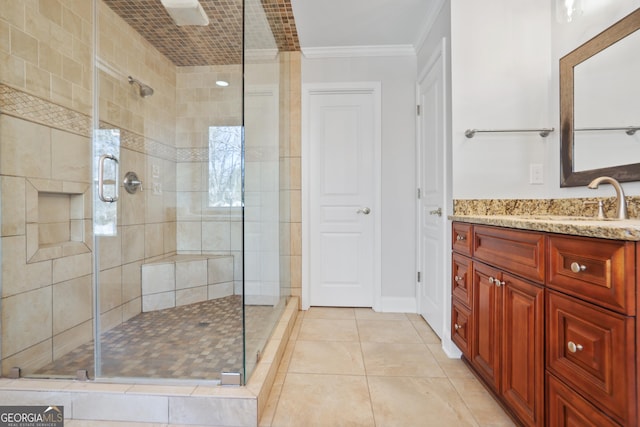 bathroom with ornamental molding, a shower with shower door, tile patterned flooring, and vanity