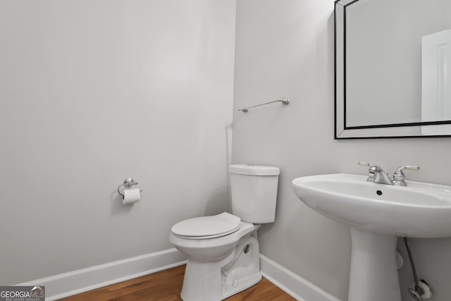 bathroom featuring sink, wood-type flooring, and toilet