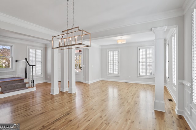 4974 Dovecote Trl, Suwanee, GA 30024 - unfurnished living room featuring ornate columns, stairs, plenty of natural light, light wood-type flooring, and ornamental molding
