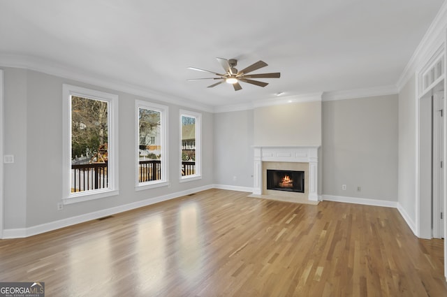 unfurnished living room with light hardwood / wood-style flooring, ornamental molding, and ceiling fan