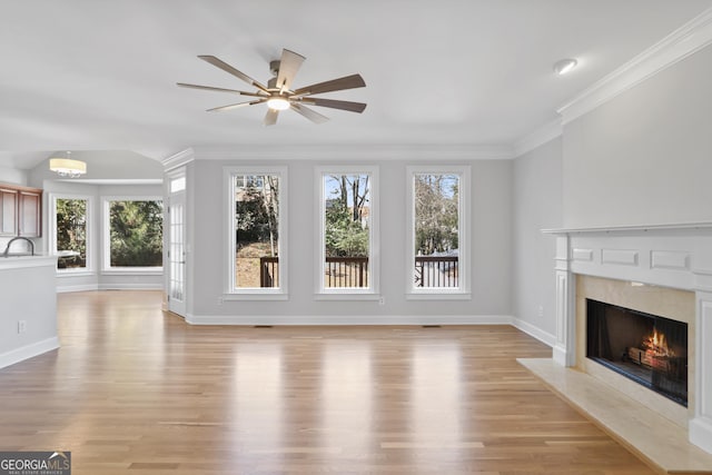 4974 Dovecote Trl, Suwanee, GA 30024 - unfurnished living room featuring healthy amount of natural light, light wood-type flooring, a fireplace, and crown molding