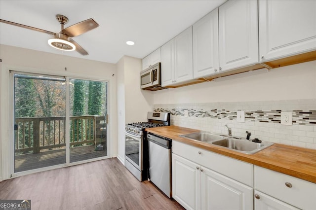 kitchen featuring white cabinetry, appliances with stainless steel finishes, sink, and wood counters