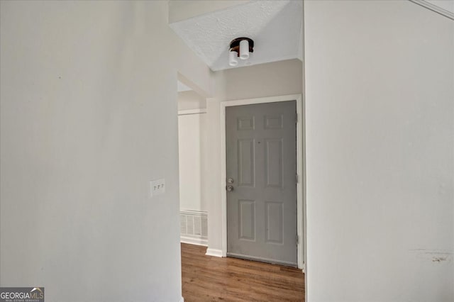 hallway featuring hardwood / wood-style floors and a textured ceiling