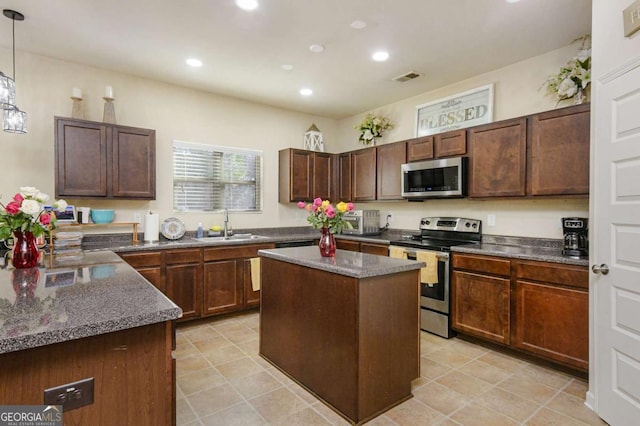 kitchen with a kitchen island, appliances with stainless steel finishes, sink, hanging light fixtures, and dark brown cabinets