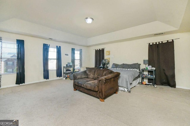 bedroom featuring a tray ceiling and carpet flooring