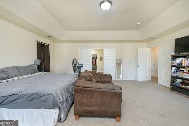 carpeted bedroom with a raised ceiling