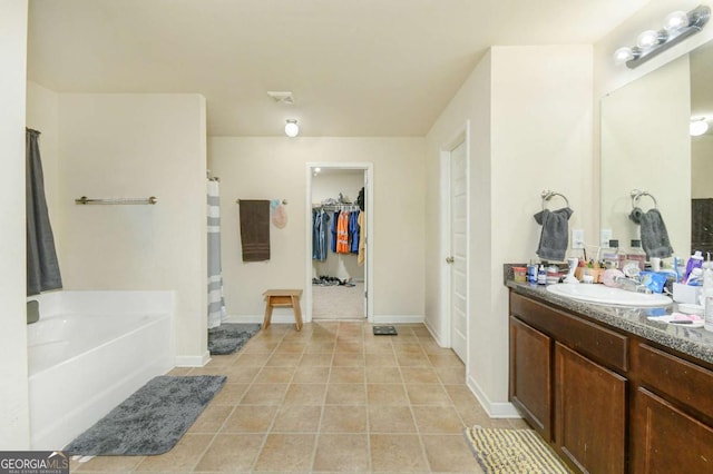 bathroom with vanity, tile patterned floors, and a tub to relax in