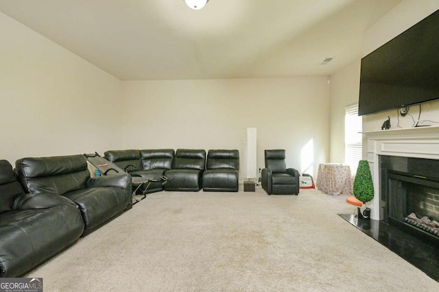 living room with a tiled fireplace and carpet flooring