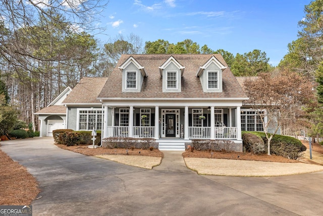 cape cod house featuring a porch and a garage