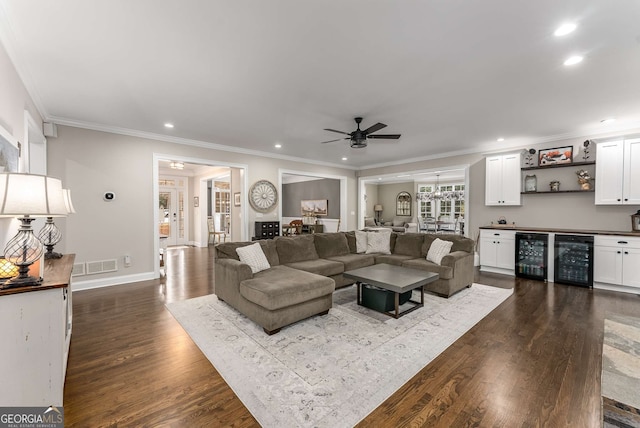 living room featuring wine cooler, indoor bar, dark hardwood / wood-style flooring, and crown molding