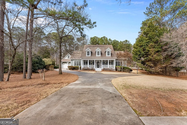 new england style home featuring a porch and a garage