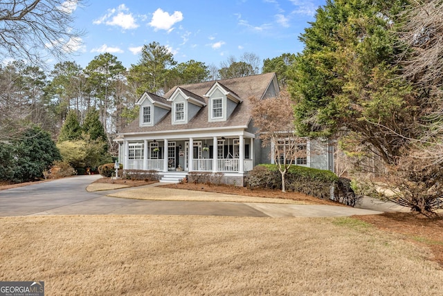 new england style home featuring a front lawn and a porch