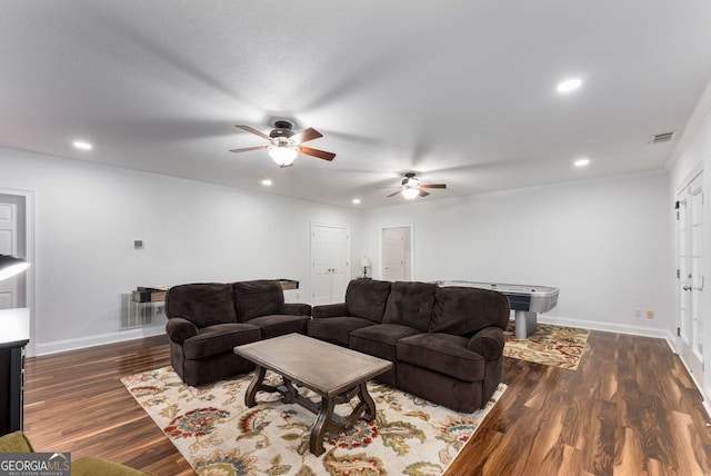 living room featuring dark wood-type flooring and ceiling fan