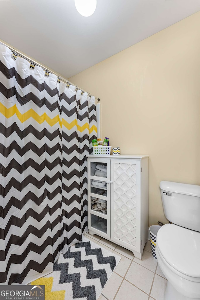 bathroom featuring a shower with curtain, tile patterned floors, and toilet