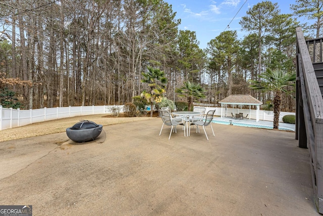 view of patio / terrace featuring a fenced in pool, a gazebo, and a fire pit