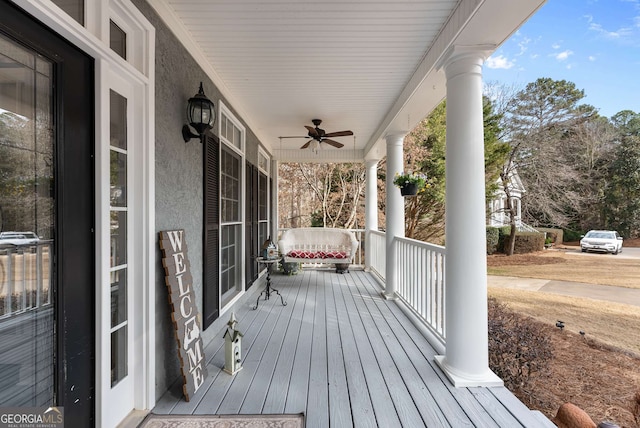 wooden terrace featuring ceiling fan and a porch