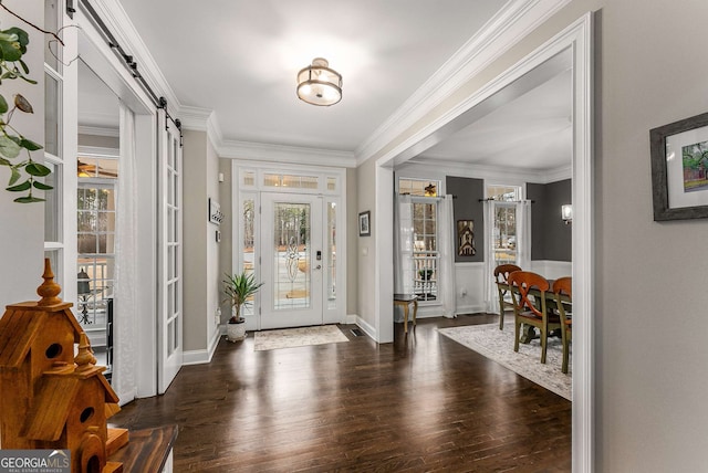 entryway with crown molding, a barn door, and dark hardwood / wood-style flooring