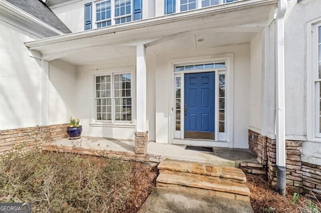 property entrance featuring stone siding and a porch