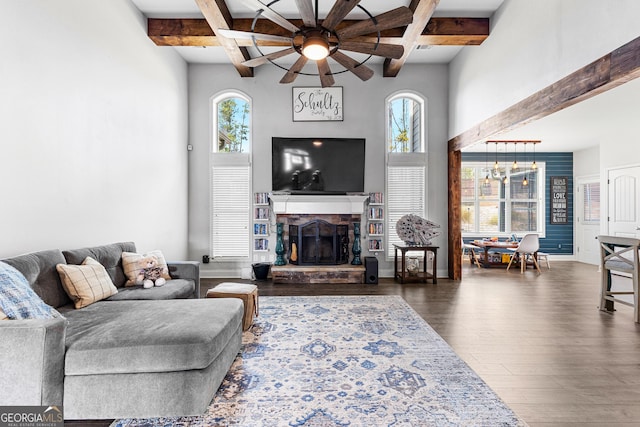 living room with coffered ceiling, beam ceiling, dark hardwood / wood-style floors, ceiling fan, and a fireplace