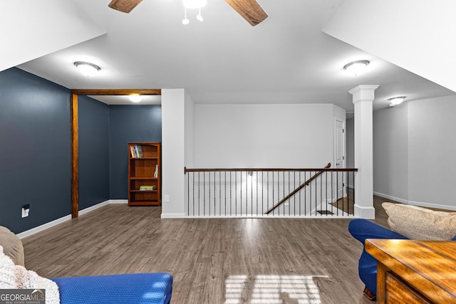 unfurnished room featuring wood-type flooring, decorative columns, and ceiling fan