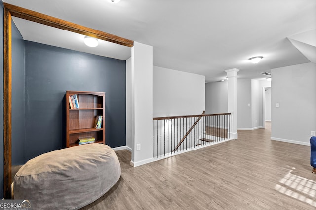 living area with hardwood / wood-style flooring and decorative columns