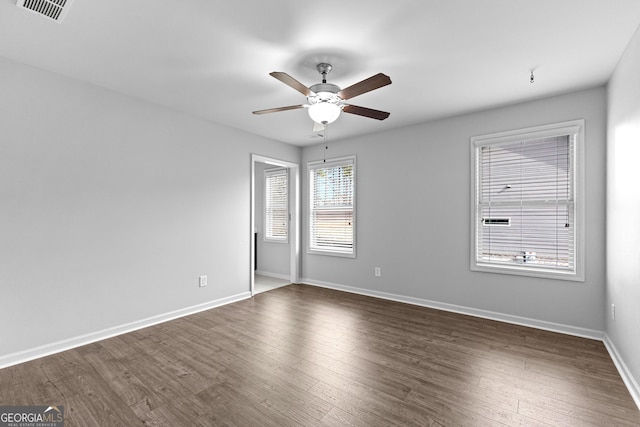 empty room with dark wood-type flooring and ceiling fan