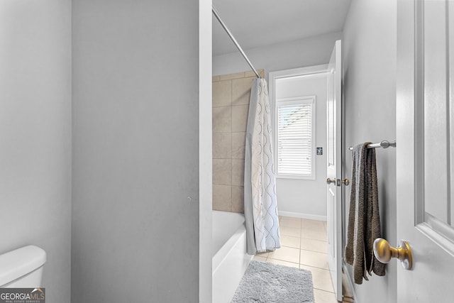 bathroom featuring tile patterned flooring, shower / bath combination with curtain, and toilet