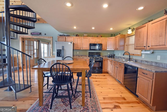 kitchen featuring plenty of natural light, sink, light wood-type flooring, and black appliances