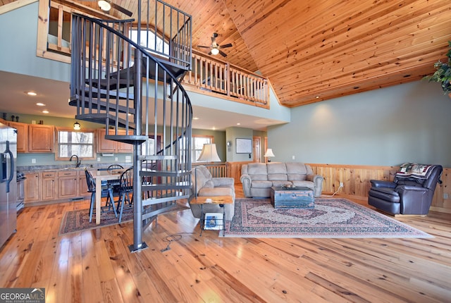 living room featuring wood ceiling, high vaulted ceiling, sink, and light hardwood / wood-style flooring