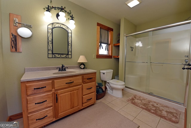 bathroom featuring vanity, tile patterned flooring, a shower with shower door, and toilet