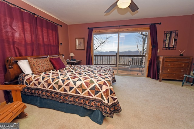 bedroom featuring a mountain view, carpet floors, access to exterior, and ceiling fan