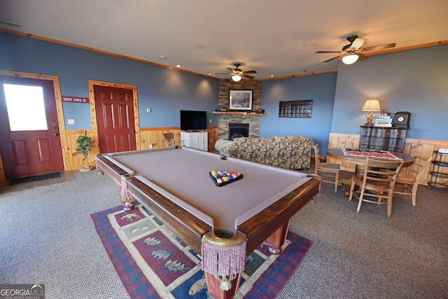 rec room with a stone fireplace, pool table, ornamental molding, carpet floors, and ceiling fan