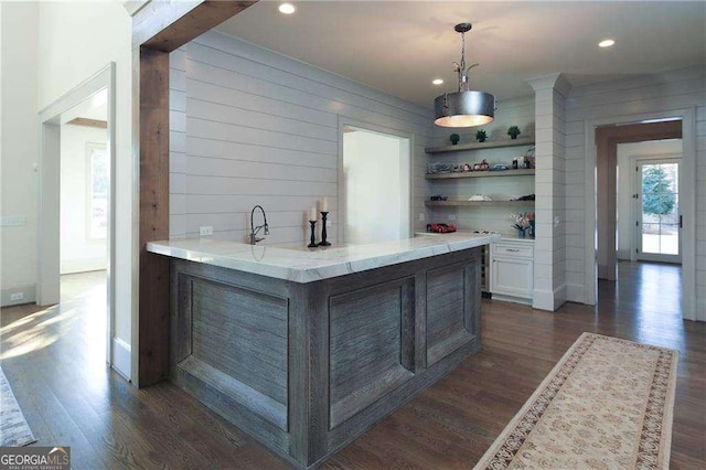 bar featuring decorative light fixtures, dark hardwood / wood-style flooring, and white cabinets