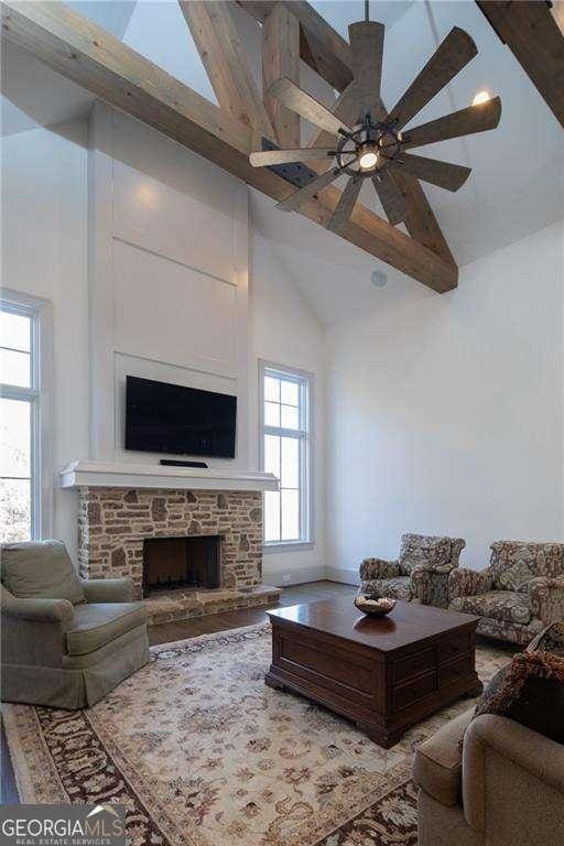5152 Boulder Bluff Way, Suwanee, GA 30024 - living room with high vaulted ceiling, healthy amount of natural light, a fireplace, beamed ceiling, and a ceiling fan