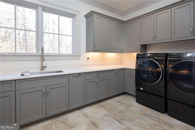 clothes washing area featuring cabinets, separate washer and dryer, and sink