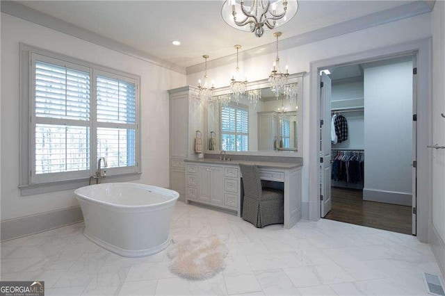 bathroom featuring vanity, a bathtub, and an inviting chandelier