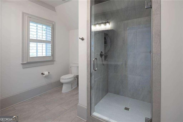 bathroom with a shower with shower door and toilet