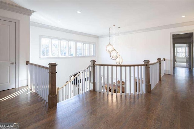 staircase featuring an inviting chandelier, hardwood / wood-style floors, and ornamental molding