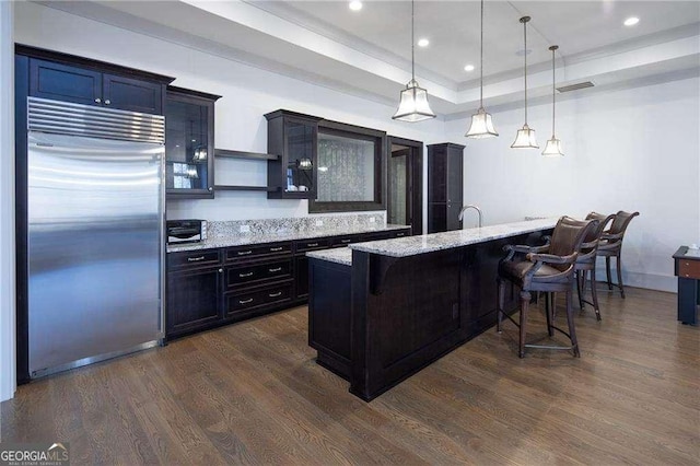 5152 Boulder Bluff Way, Suwanee, GA 30024 - kitchen featuring built in refrigerator, a breakfast bar, dark wood finished floors, hanging light fixtures, and recessed lighting
