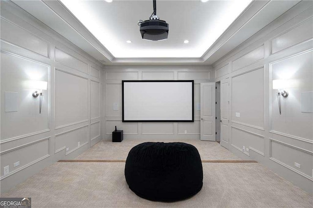 home theater featuring crown molding, light colored carpet, and a raised ceiling