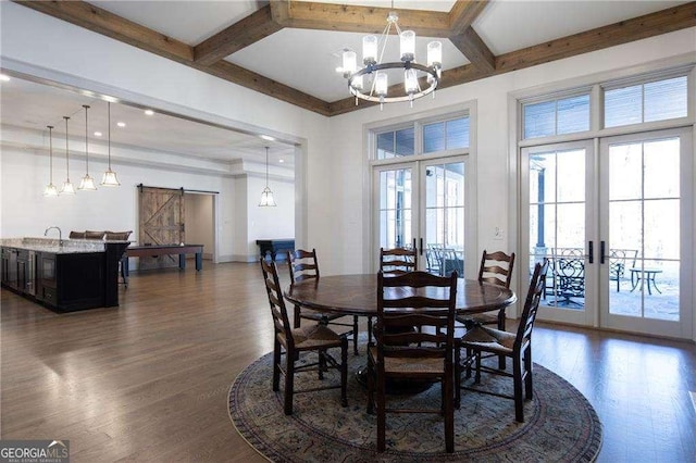 dining area with coffered ceiling, a barn door, dark wood-type flooring, and french doors