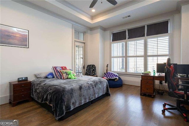 bedroom featuring dark hardwood / wood-style flooring and a raised ceiling