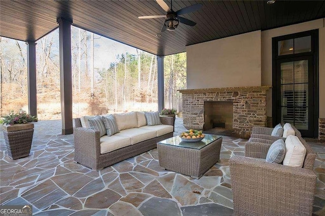 view of patio / terrace featuring an outdoor living space with a fireplace and ceiling fan