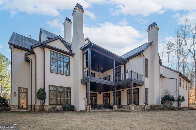 back of house featuring a balcony, a yard, and ceiling fan