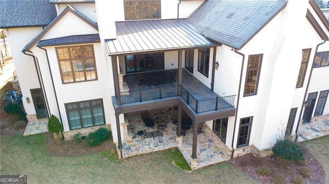 5152 Boulder Bluff Way, Suwanee, GA 30024 - rear view of house featuring stucco siding, a standing seam roof, a patio, and a balcony